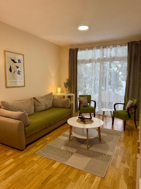 a living room with a green couch and a table at Hotel Villa Perla Di Mare in Budva