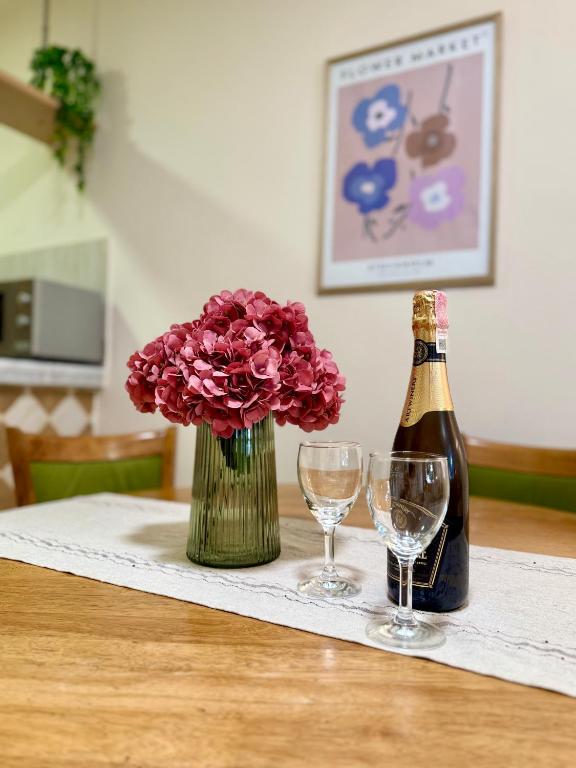 a bottle of champagne and flowers and glasses on a table at Hotel Villa Perla Di Mare in Budva