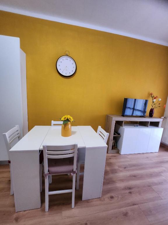 a dining room with a table and a clock on a yellow wall at Maja in Chiavari