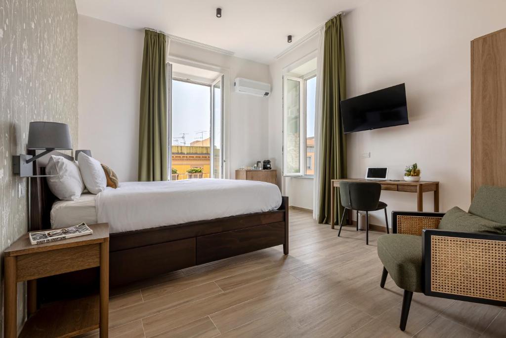 a bedroom with a bed and a desk and a couch at Riviera Collection - Rooms and Suites in Naples