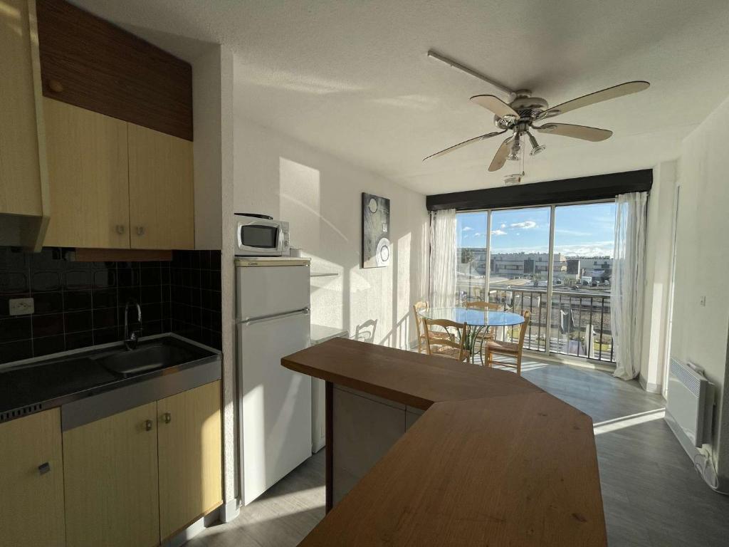 une cuisine avec ventilateur de plafond et une cuisine avec vue dans l'établissement Appartement Héliopolis F 51 - Classique - 4 personnes, au Cap d'Agde