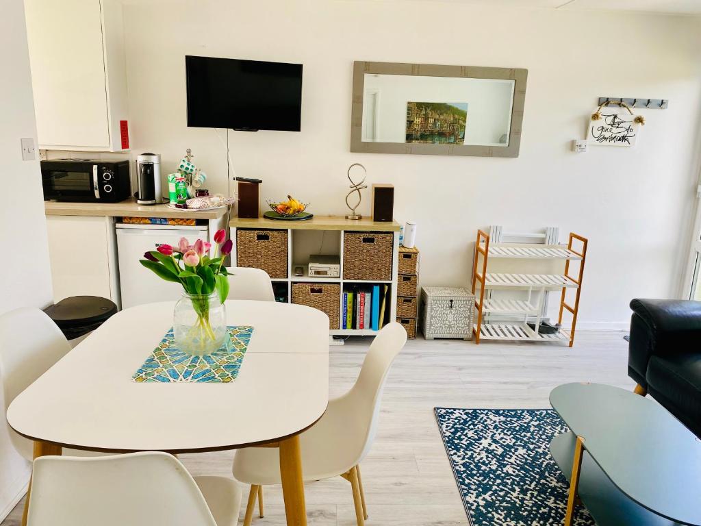 un salon avec une table et des chaises blanches dans l'établissement Dart Dream, à Dartmouth