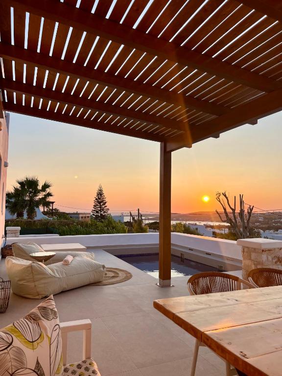 a patio with a wooden pergola and a table at thEros - apartment 2 in Parikia