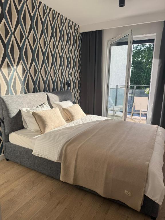 Hotel Apartament Centro z bezpłatnym garażem, a large bed in a bedroom with a wall at Apartament Centro z bezpłatnym garażem in Toruń