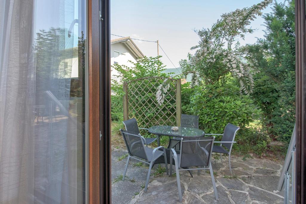 a table and chairs on a patio outside a window at Haus unter Gerlitzen in Bodensdorf