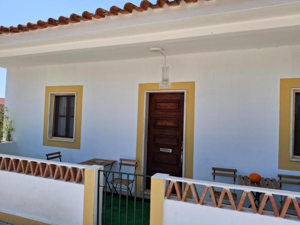 a balcony with a table and chairs and a door at Casa na Quinta in Elvas