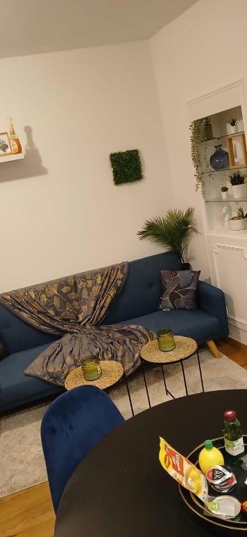 un salon avec un canapé bleu et une table dans l'établissement Studio familial, à Paris