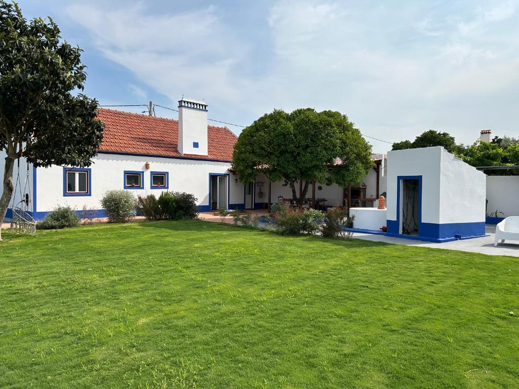 ein weißes Haus mit grünem Rasen davor in der Unterkunft Villa Morena in Grândola