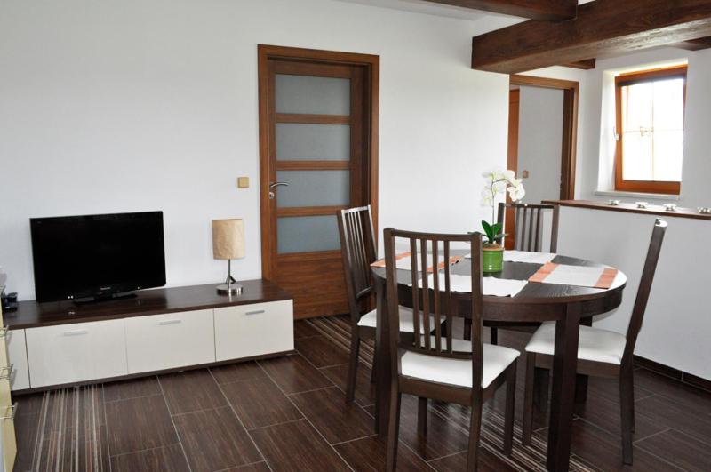a living room with a dining room table and a television at Apartmány Lipno - Frymburk in Frymburk