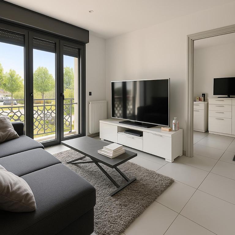 un salon avec un canapé et une télévision à écran plat dans l'établissement Thanh Ho entre Disneyland et Paris-parking Gratuit, à Gournay-sur-Marne