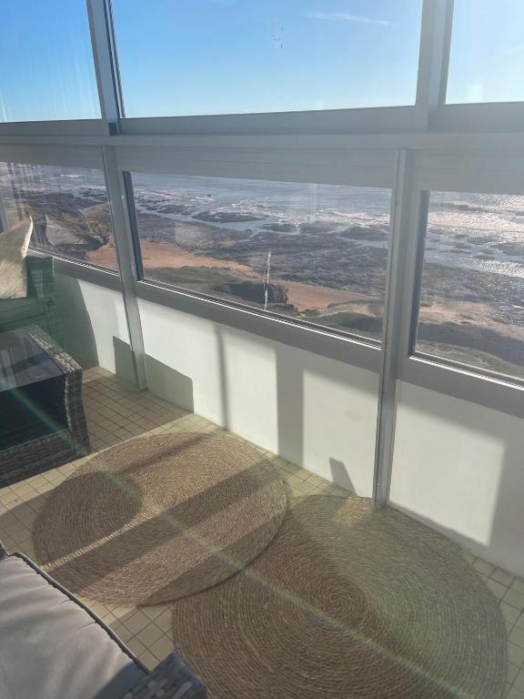 Cette chambre dispose d'une grande fenêtre avec un lit et une table. dans l'établissement Appartement vue mer, à Saint-Hilaire-de-Riez