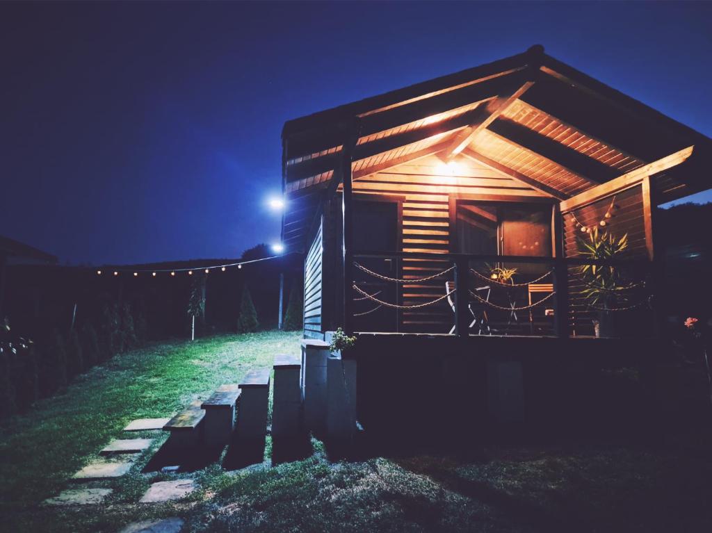 a cabin at night with lights on the front at La Ograda - Cheile Turzii, near Turda in Sănduleşti