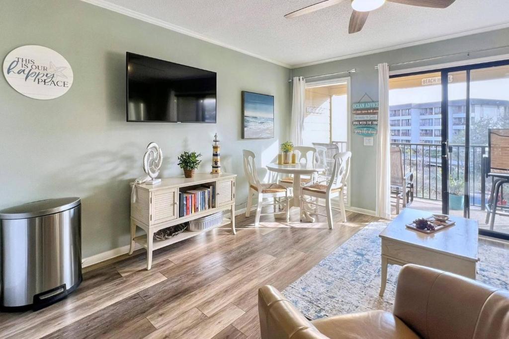 a living room with a table and a dining room at Salty Air & Sea Breezes in Hilton Head Island