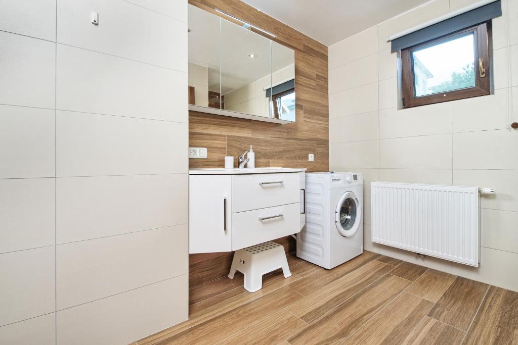 a white bathroom with a washing machine in it at Haus unter Gerlitzen in Bodensdorf