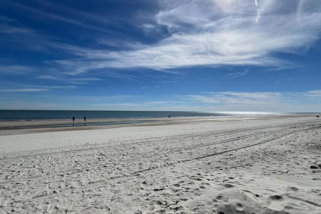 a beach with people walking on the sand and the ocean at Dunes with Design in Hilton Head Island