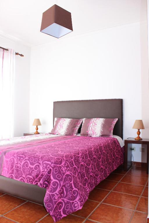 a bedroom with a bed with a pink bedspread at Baleal Holiday Apartment in Baleal