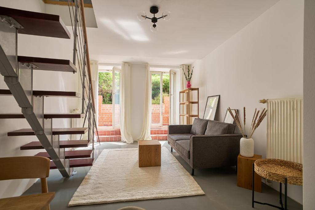 a living room with a couch and a staircase at Ruhiges zentrales Maisonette-Loft in Berlin in Berlin