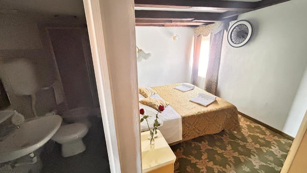 uma pequena casa de banho com uma cama e um lavatório em Casa Lin Venice Zimmer em Veneza