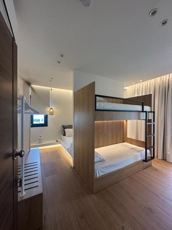 a room with two bunk beds and a bathroom at Mare Beach Apartments in Stavros