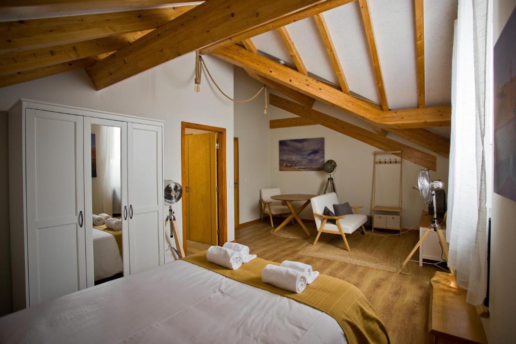 a bedroom with a large bed in a room with wooden ceilings at Guest House 10 de Agosto in Figueira da Foz