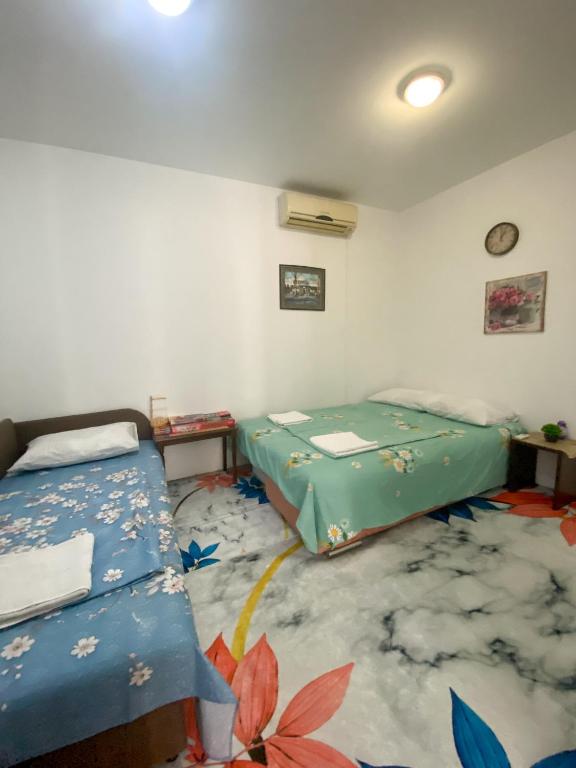 a room with two beds and a carpet at Secret Garden Mostar in Mostar