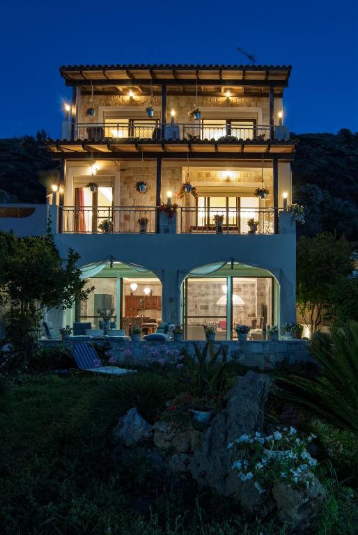 a large house at night with lights at Apartment Villa Omega in Agia Pelagia