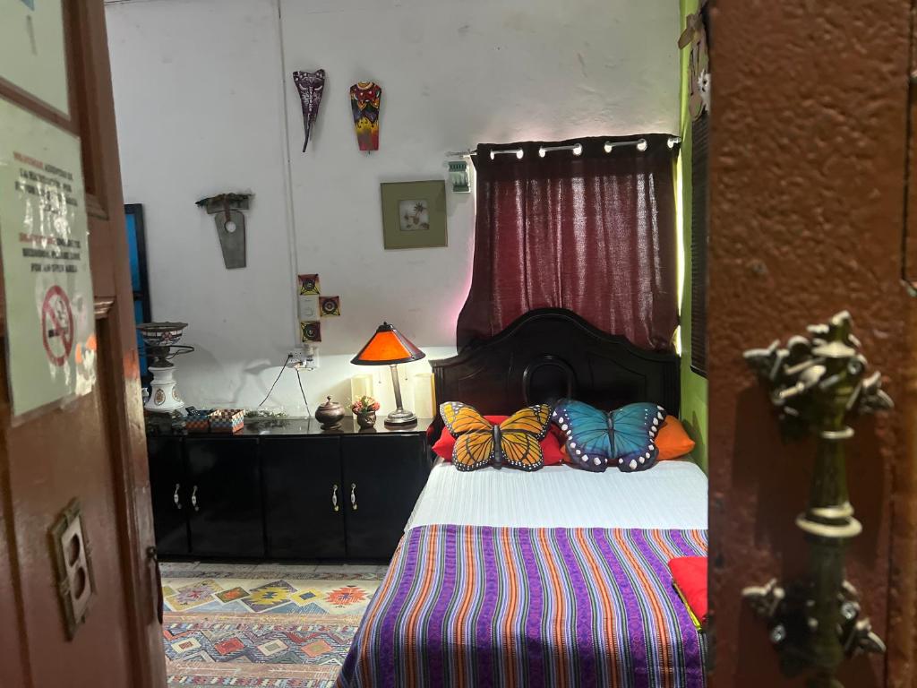 ein Schlafzimmer mit einem Bett mit Schmetterlingskissen darauf in der Unterkunft Mendoza’s GUESTHOUSE in Santa Ana