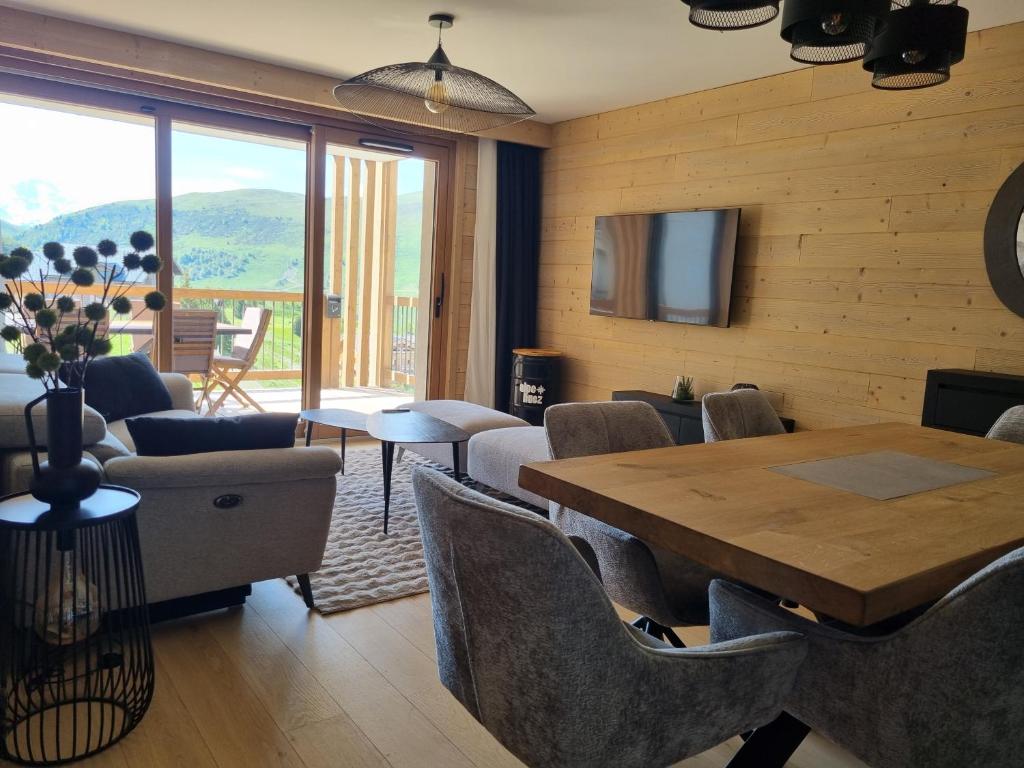 una sala da pranzo con tavolo e sedie in legno di Apartment 70 m2 - 3 rooms - 6 people - ski-in ski-out a LʼAlpe-dʼHuez