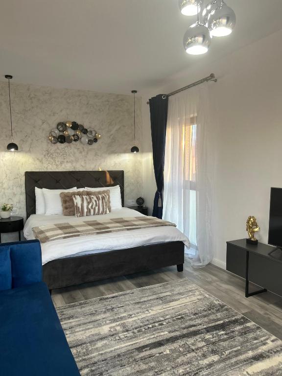 a bedroom with a large bed and a blue couch at CASAMORE Rentals in Braşov
