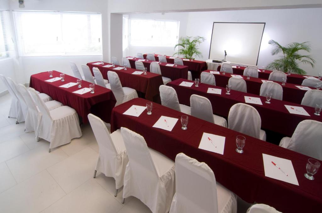 a room with red and white tables and chairs at Adhara Express in Cancún