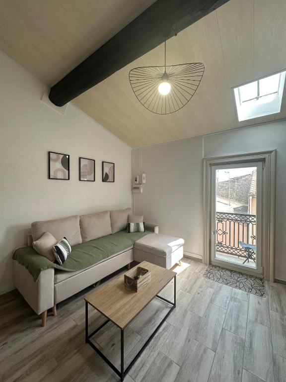 un salon avec un canapé et une table dans l'établissement Charmant appartement climatisé, à Sérignan