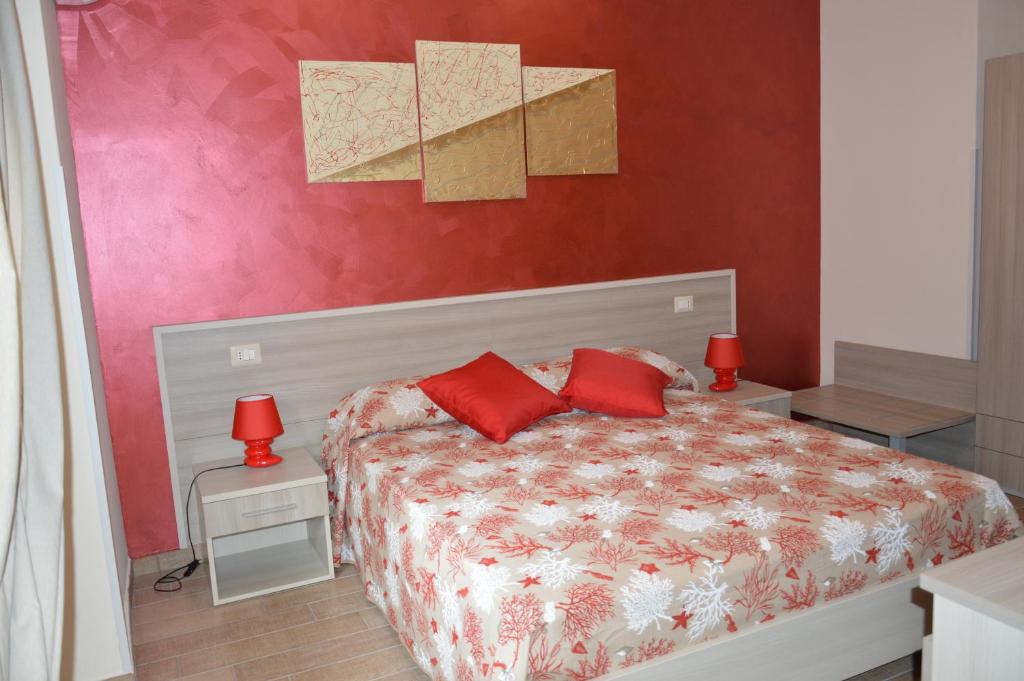 Un dormitorio con una cama con almohadas rojas. en La Conchiglia, en Tropea