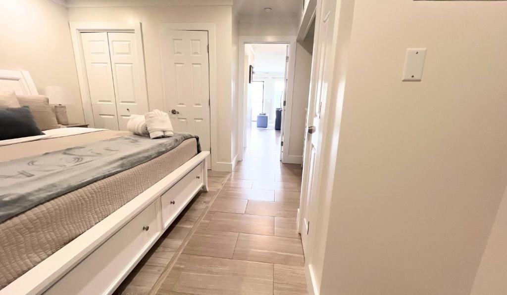 a white bedroom with a bed and a hallway at Southern Serenity, an HHI Beachfront Resort in Hilton Head Island