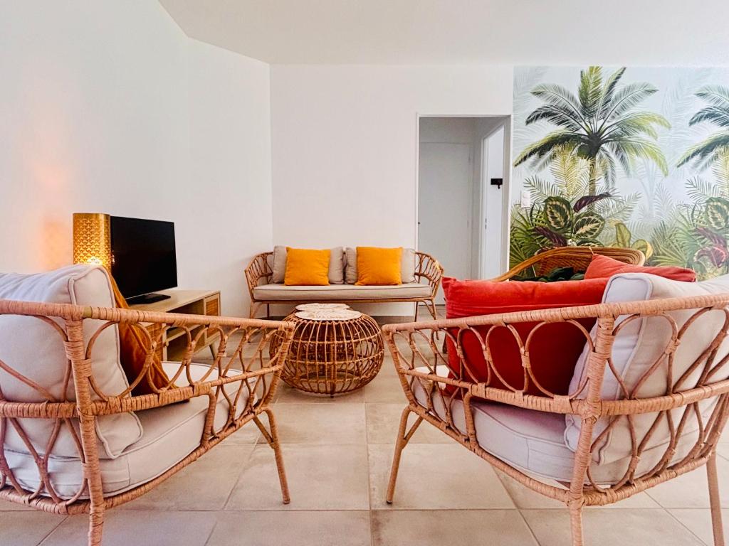 un salon avec deux chaises et une télévision dans l'établissement Maison neuve 4 etoiles à 10 minutes de Royan, à Le Chay