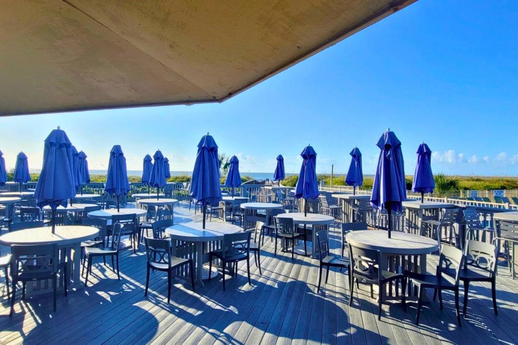 a row of tables and chairs with umbrellas at Southern Serenity, an HHI Beachfront Resort in Hilton Head Island