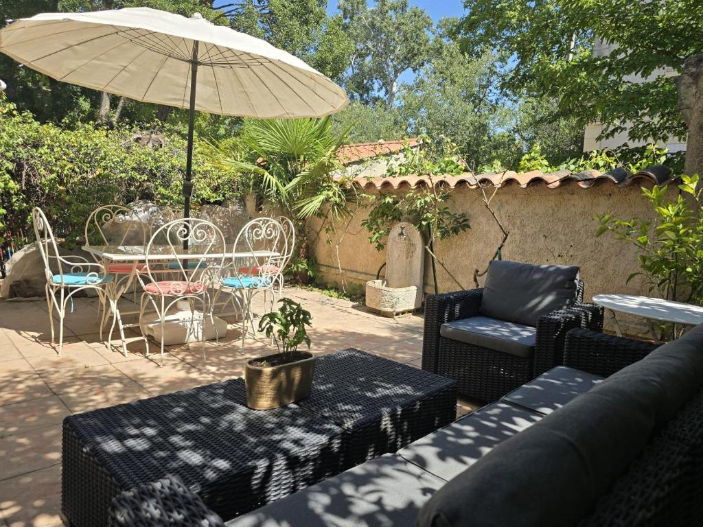 un patio avec une table, des chaises et un parasol dans l'établissement 3 Bedroom House Terrace Park & Free Parking, à Aix-en-Provence