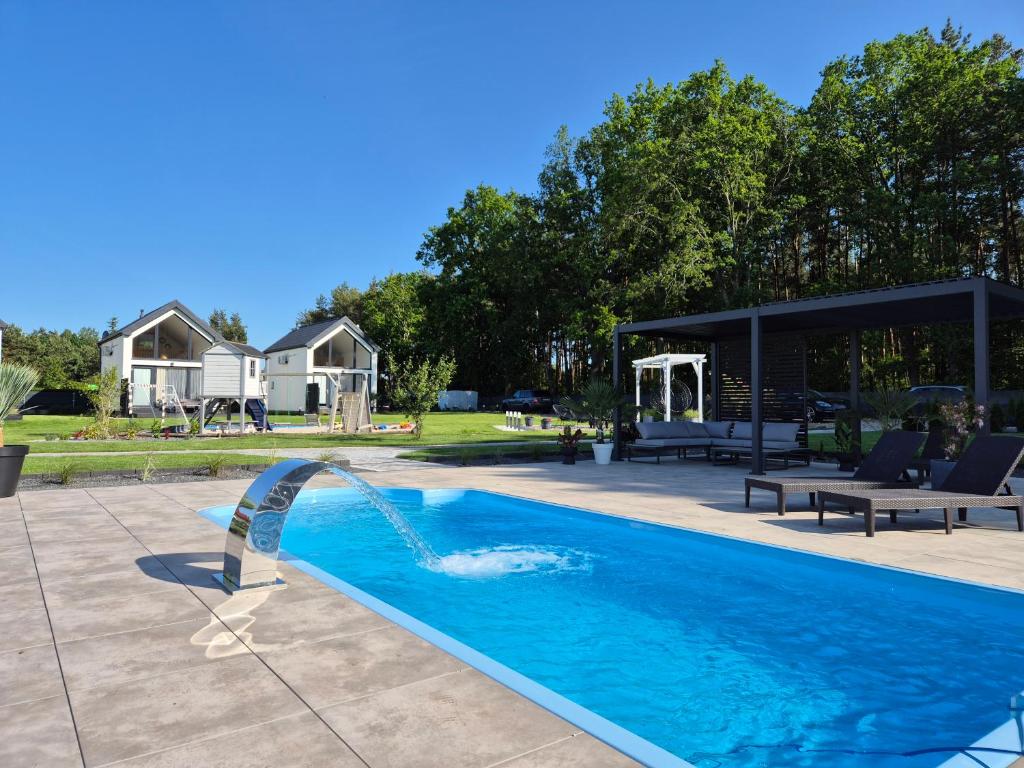 a pool with a water fountain in a yard at My Slow Stay Łeba in Szczenurze