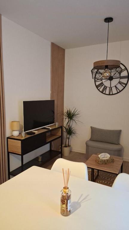 un salon avec une table et un bureau avec une télévision dans l'établissement Charmant petit appartement avec terrasse, à Agen