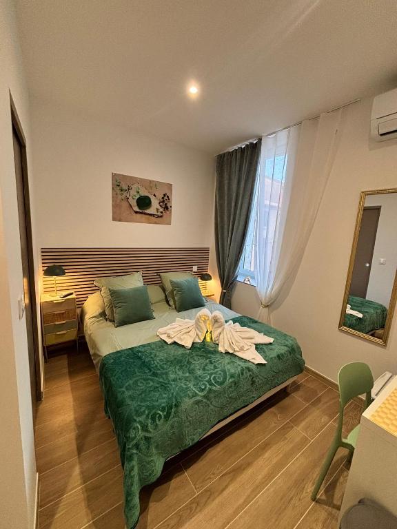 une chambre avec un lit avec une fleur dessus dans l'établissement La Jade, à Narbonne