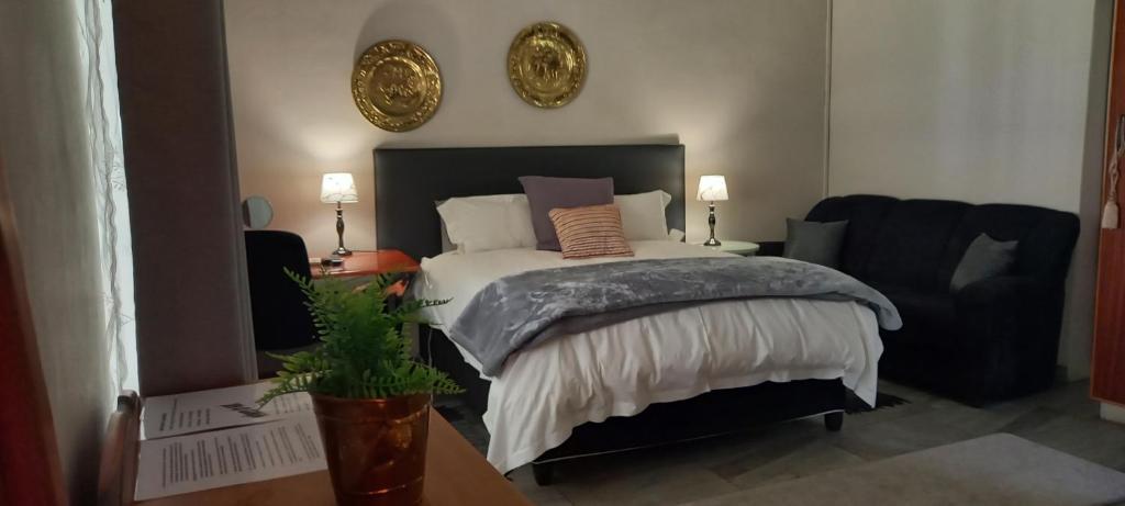 a bedroom with a large bed and a chair at Altenburgh Accommodation - Apartments in Somerset East