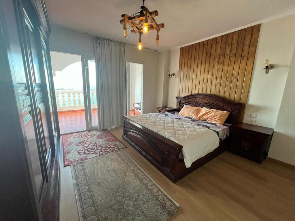 エル・アラメインにあるفيلا دوبلكس 3 غرف بورتو مارينا الفندقيه للأسر فقطのベッドとシャンデリアのある寝室