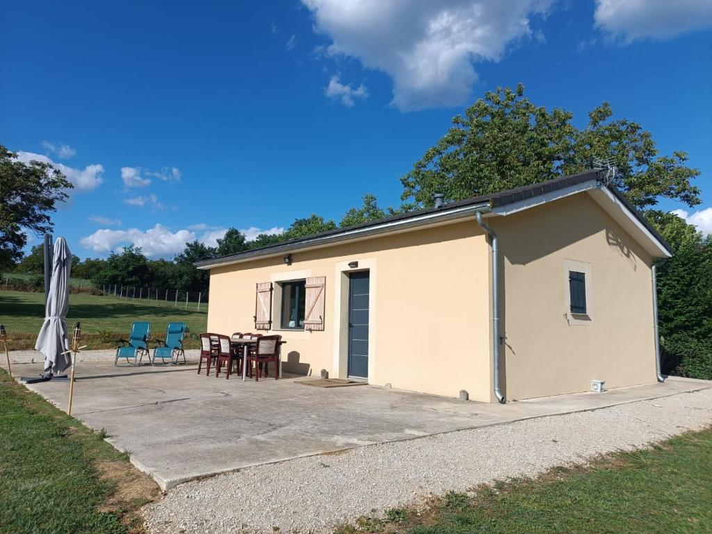 - un petit bâtiment blanc avec une table et des chaises dans l'établissement maison de campagne, à Saint-Aubin-de-Nabirat