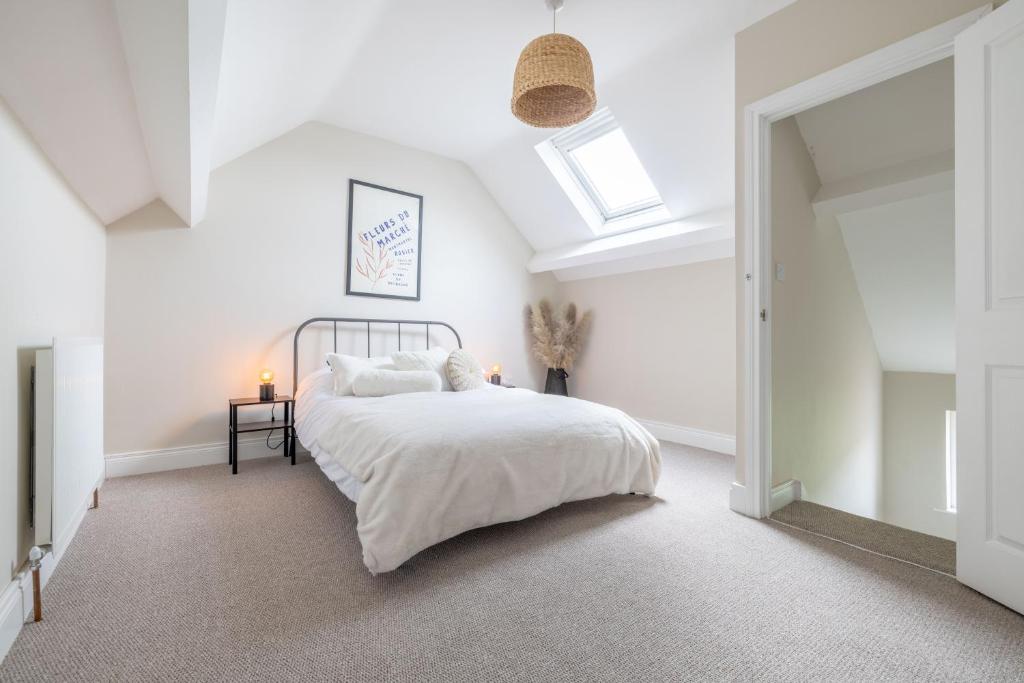 a white bedroom with a bed and a skylight at Hillview House in Belfast