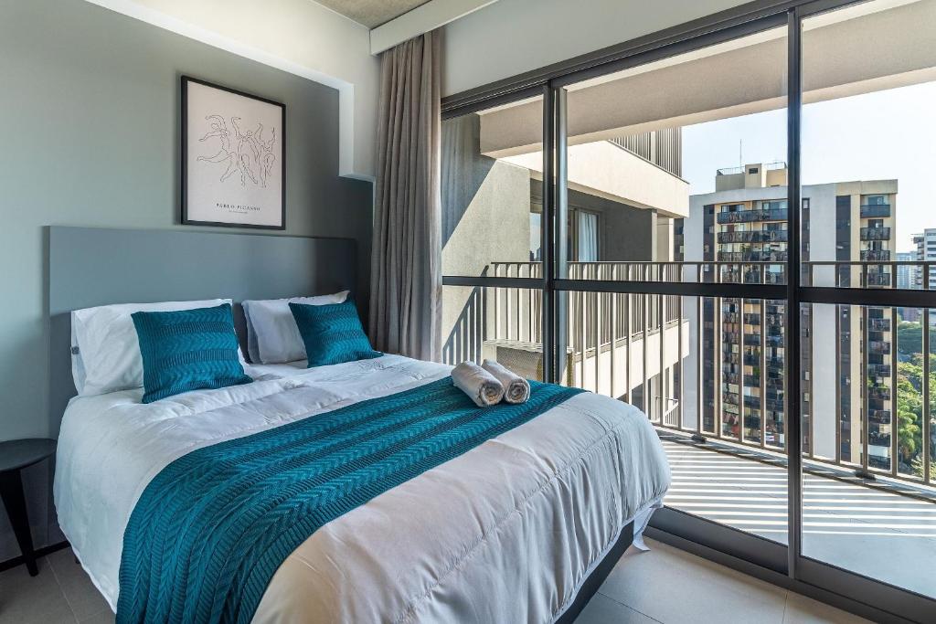 a bedroom with a large bed and a balcony at LG1308 - Studio moderno | ao lado Metrô Santa Cruz in Sao Paulo