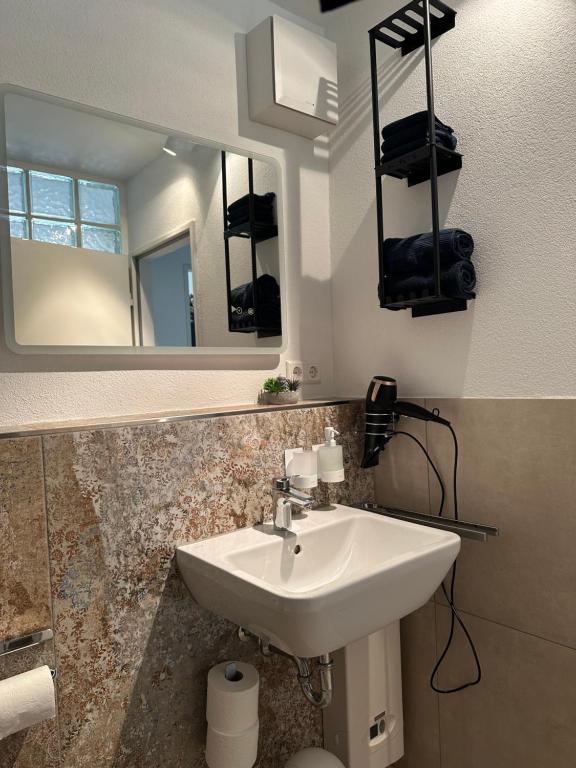a bathroom with a sink and a mirror at Kleine Perle mit Bodenseeblick und Sonnenterrasse in Daisendorf