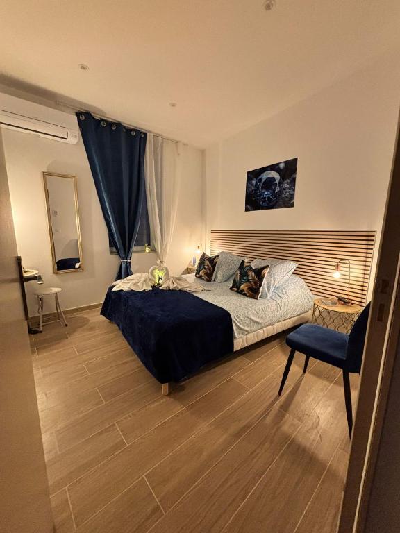 une chambre avec un grand lit et une chaise dans l'établissement La Saphir, à Narbonne
