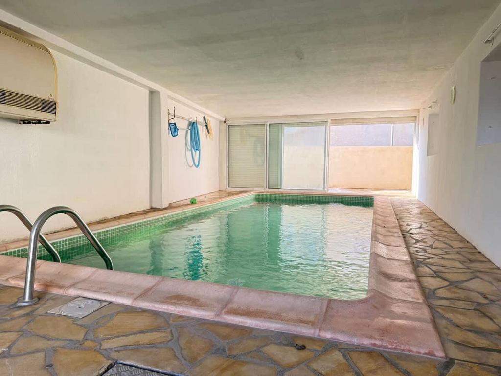 une grande piscine dans une pièce avec de l'eau verte dans l'établissement Villa & Appartement avec Piscine Interieure, à Valras-Plage