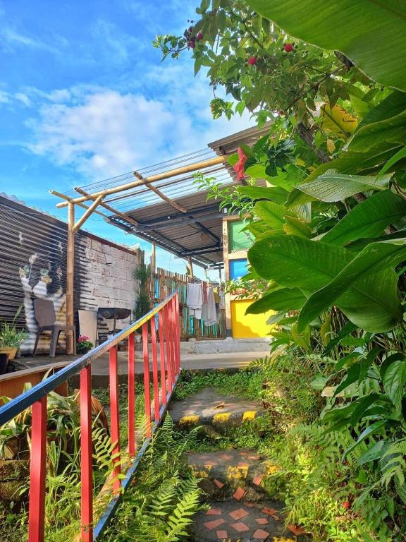 a patio with a red fence and some plants at Kimaná Hostal in Santa Rosa de Cabal