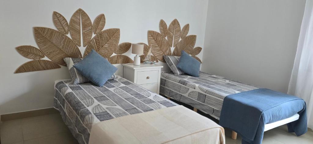 a bedroom with two beds and a plant on the wall at Quinta Do Vale 32 by AL in Guia