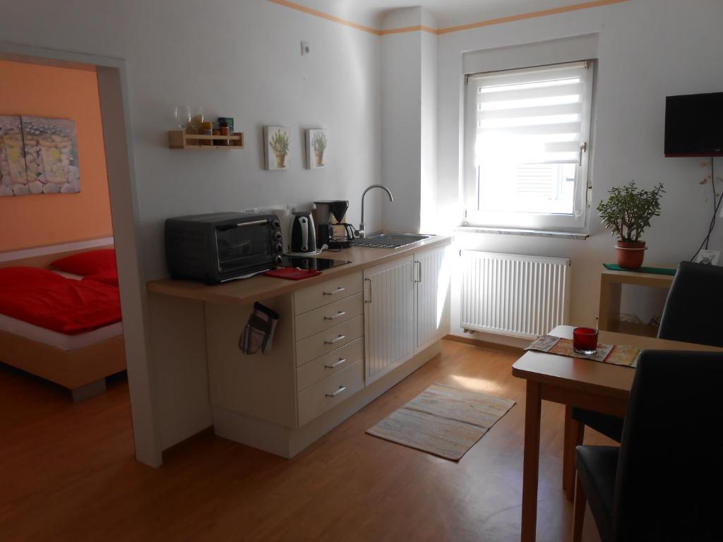 a room with a kitchen with a microwave and a table at Main(schlaf)erlebnis in Karlstadt